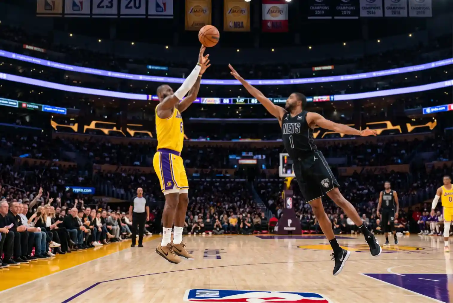 Pista de baloncesto profesional de la NBA durante un partido nocturno con jugadores en acción y un balón naranja en el aire